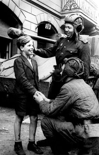 Russian soldiers are greeting a German boy